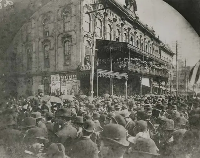 A dense crowd of men in hats filling Marietta Street in front of DeGive’s Opera House, its balconies crowded, at the unveiling of the Grady monument in 1891.