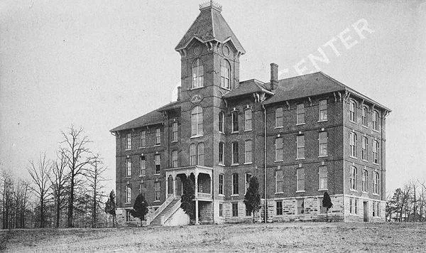 Chrisman Hall at Clark University in 1895: a large brick building with a central tower on open ground.