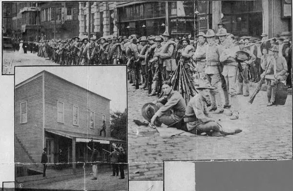 Militia soldiers halted in ranks on Marietta Street near Peachtree in 1906, with a wooden building and a group of Black men seated on the ground in an inset.