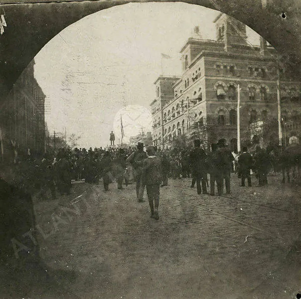 A crowd filling Marietta Street, seen through an arch, at the unveiling of the Grady monument in 1891.