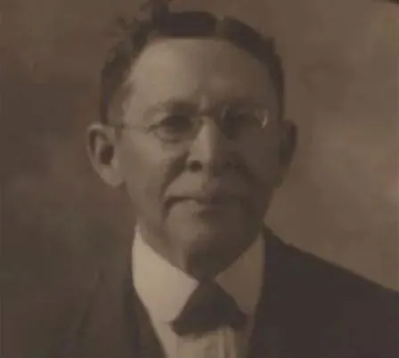 A portrait photograph of Luther Judson Price, a Black man with a white beard in a dark suit.