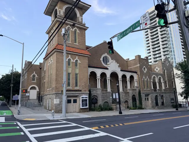 The church tower above the traffic signal at the corner.