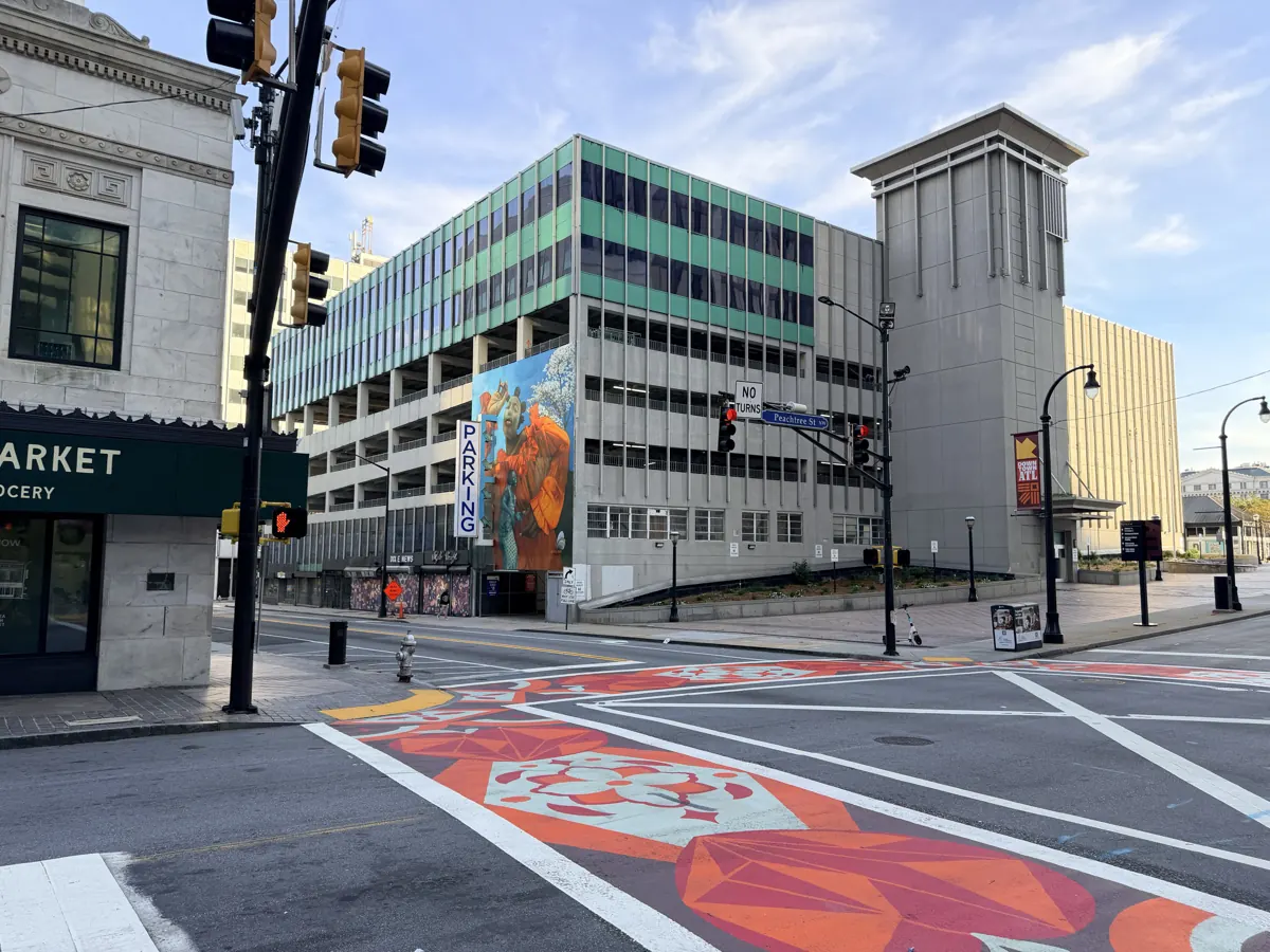 Five Points in downtown Atlanta today: a painted crosswalk, traffic lights and a parking deck with a mural.