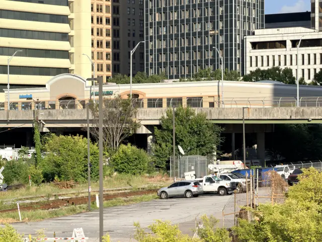 The gulch from the bridge, the MARTA station and parked cars below.