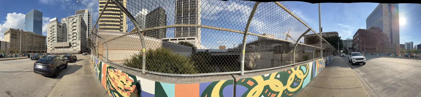 A wide view from Forsyth Street: the fenced gulch, the parking lot where the Austell Building stood, and the towers around it.