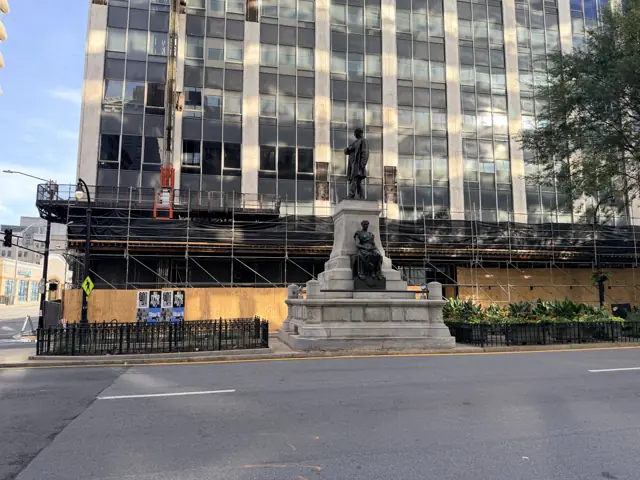 The monument from the side, scaffolding on the building behind it.